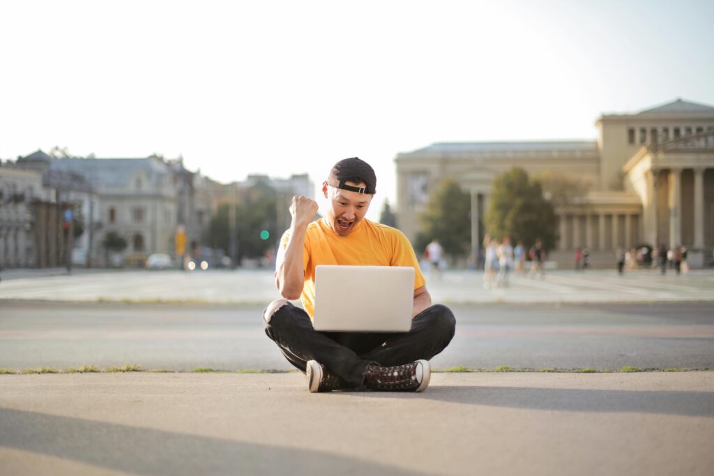 Digital nomad-friendly cities with a man sitting on the ground pressing laptop